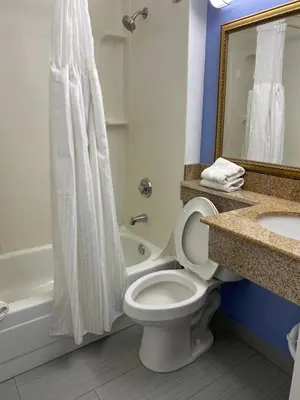 a bathroom with a toilet and a sink and a tub at Executive Inn Chillicothe in Chillicothe