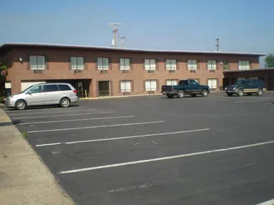 a parking lot with cars parked in front of a building at Executive Inn Chillicothe in Chillicothe
