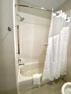 a bathroom with a tub and a shower with a shower curtain at Holiday Inn Express & Suites Elyria by IHG in Elyria