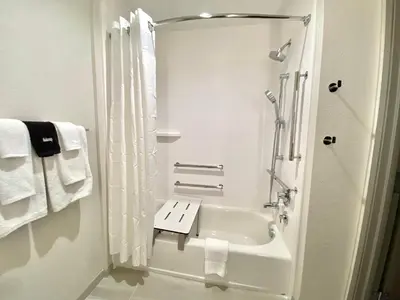 a white bathroom with a shower and a sink at Holiday Inn Express & Suites Elyria by IHG in Elyria