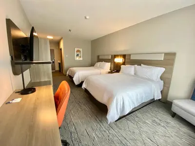 a hotel room with two beds and a couch at Holiday Inn Express & Suites Elyria by IHG in Elyria