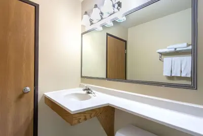 a bathroom with a sink and a large mirror at Super 8 by Wyndham Youngstown/Austintown in Youngstown