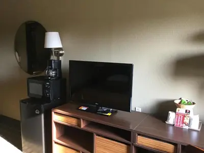 a flat screen tv sitting on top of a wooden entertainment center at Super 8 by Wyndham Youngstown/Austintown in Youngstown