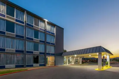 a large building with a parking lot in front of it at Days Inn by Wyndham Cambridge in Cambridge