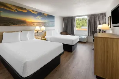 a hotel room with two beds and a window at Days Inn by Wyndham Cambridge in Cambridge
