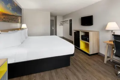 a hotel room with a large bed and a tv at Days Inn by Wyndham Cambridge in Cambridge