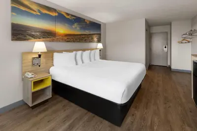 a hotel room with a large bed and a painting on the wall at Days Inn by Wyndham Cambridge in Cambridge