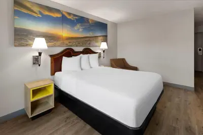 a bedroom with a white bed and a painting on the wall at Days Inn by Wyndham Cambridge in Cambridge