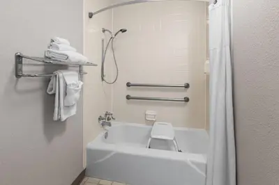 a bathroom with a tub and a toilet and towels at Days Inn by Wyndham Cambridge in Cambridge