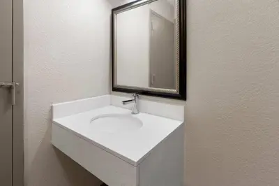 a bathroom with a white sink and a mirror at Days Inn by Wyndham Cambridge in Cambridge