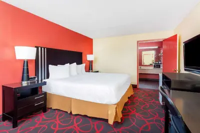 a hotel room with a bed and a flat screen tv at Travelodge by Wyndham Richmond IN in Richmond