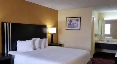 a hotel room with a bed and a bathroom at Travelodge by Wyndham Richmond IN in Richmond