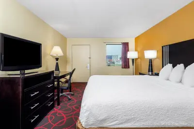 a hotel room with a bed and a flat screen tv at Travelodge by Wyndham Richmond IN in Richmond