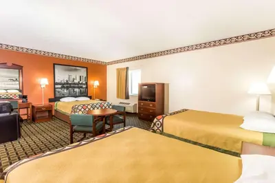 a hotel room with two beds and a desk at Super 8 by Wyndham Athens in Athens