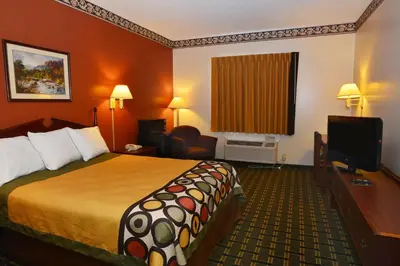 a hotel room with a bed and a flat screen tv at Super 8 by Wyndham Athens in Athens