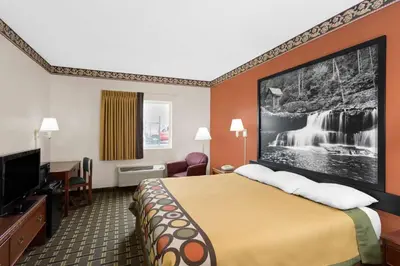 a hotel room with a bed and a flat screen tv at Super 8 by Wyndham Athens in Athens