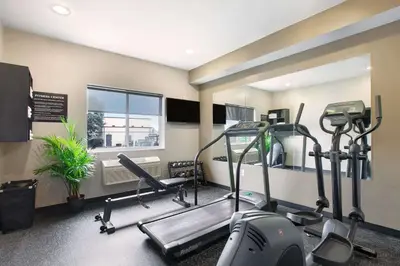 a gym with several tread machines and a window at Super 8 by Wyndham Akron S/Green/Uniontown OH in Uniontown