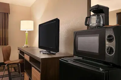 a desk with a tv and a computer monitor on it at Super 8 by Wyndham Akron S/Green/Uniontown OH in Uniontown