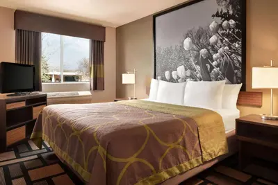 a hotel room with a bed and a television at Super 8 by Wyndham Akron S/Green/Uniontown OH in Uniontown