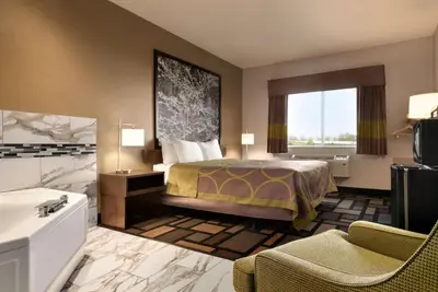 a hotel room with a bed and a bathroom at Super 8 by Wyndham Akron S/Green/Uniontown OH in Uniontown