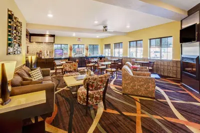 a restaurant with couches and tables and a bar at Super 8 by Wyndham Akron S/Green/Uniontown OH in Uniontown