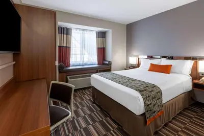 a hotel room with a bed and a television at Microtel Inn & Suites by Wyndham Sunbury - Columbus North in Sunbury