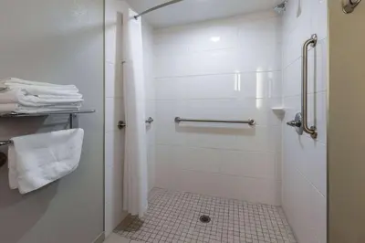 a bathroom with a shower with white tiles at Microtel Inn & Suites by Wyndham Sunbury - Columbus North in Sunbury