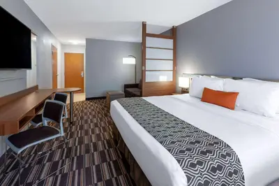a hotel room with a large bed and a desk at Microtel Inn & Suites by Wyndham Sunbury - Columbus North in Sunbury