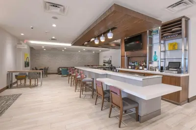 a bar in a restaurant with chairs and a counter at Hilton Garden Inn Cincinnati Midtown in Cincinnati