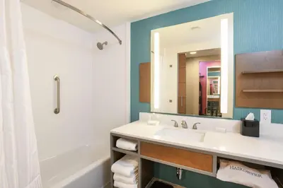a bathroom with a sink and a tub and a mirror at Hilton Garden Inn Cincinnati Midtown in Cincinnati