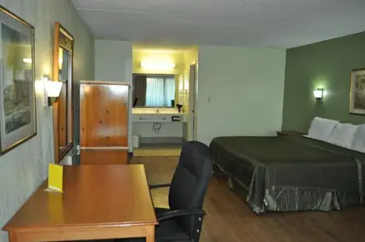 a hotel room with a bed and a desk and chair at Bestway Inn - Madison in Madison