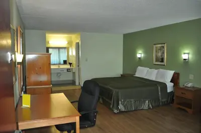 a hotel room with a bed and a desk at Bestway Inn - Madison in Madison
