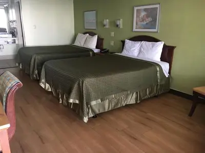 two beds in a hotel room with green walls at Bestway Inn - Madison in Madison