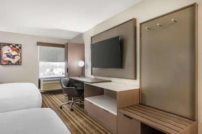 a hotel room with a bed and a desk with a television at Best Western Plus Richmond Indiana I-70 in Richmond