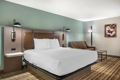 a bedroom with a large white bed and a chair at Best Western Plus Richmond Indiana I-70 in Richmond