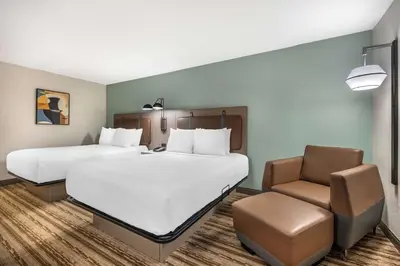 a hotel room with two beds and a chair at Best Western Plus Richmond Indiana I-70 in Richmond