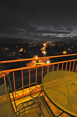 a table and a chair on a balcony at night at Hillside Inn in Madison