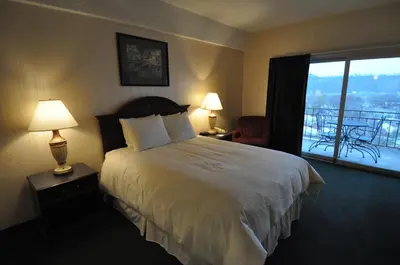 a hotel room with a bed and a balcony at Hillside Inn in Madison