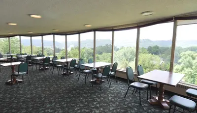 a dining room with tables and chairs and windows at Hillside Inn in Madison