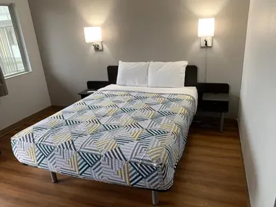 a bedroom with a bed with a colorful comforter at Motel 6-Dayton, OH in Dayton