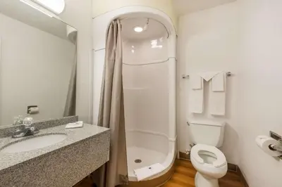 a white bathroom with a toilet and a sink at Motel 6-Dayton, OH in Dayton