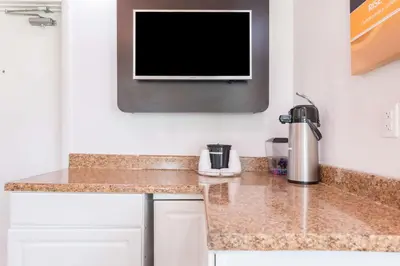 a kitchen with a counter with a tv on the wall at Motel 6-Dayton, OH in Dayton