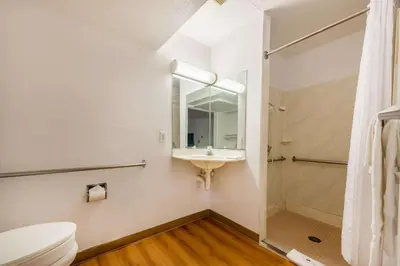 a bathroom with a toilet and a sink and a mirror at Motel 6-Dayton, OH in Dayton