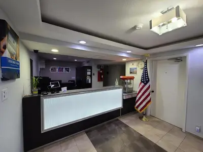 a lobby with an empty counter with an american flag at Motel 6-Dayton, OH in Dayton