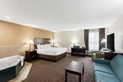 a hotel room with a bed and a bath tub at SureStay by Best Western Grayson in Grayson