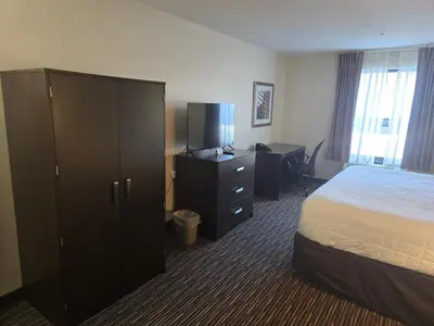 a hotel room with a bed and a dresser at SureStay by Best Western Grayson in Grayson