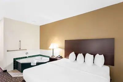 a hotel room with a bed and a bath tub at SureStay by Best Western Grayson in Grayson
