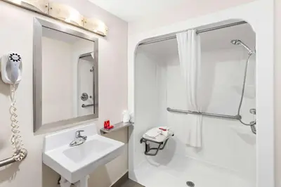 a white bathroom with a sink and a shower at SureStay by Best Western Grayson in Grayson