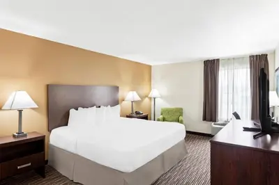 a hotel room with a large bed and a desk at SureStay by Best Western Grayson in Grayson