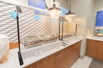 a bakery counter with trays of food on display at Holiday Inn Express & Suites - Marion by IHG in Marion